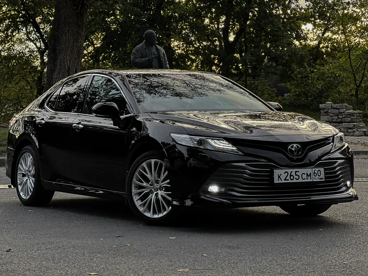 Чёрная Toyota Camry вечером в парке